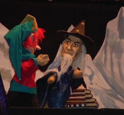 Kasperl bemerkt, dass der Torte ein Stück fehlt.